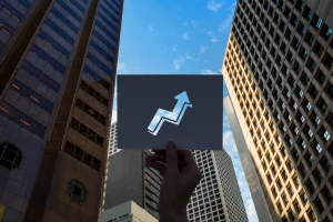 Paper cutout pointed at the blue sky with high-rise buildings in the background
