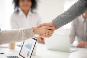 Two business partners handshake at a sales meeting in an office
